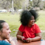 Smiling individuals bonding and enjoying leisure time in a sunny park.